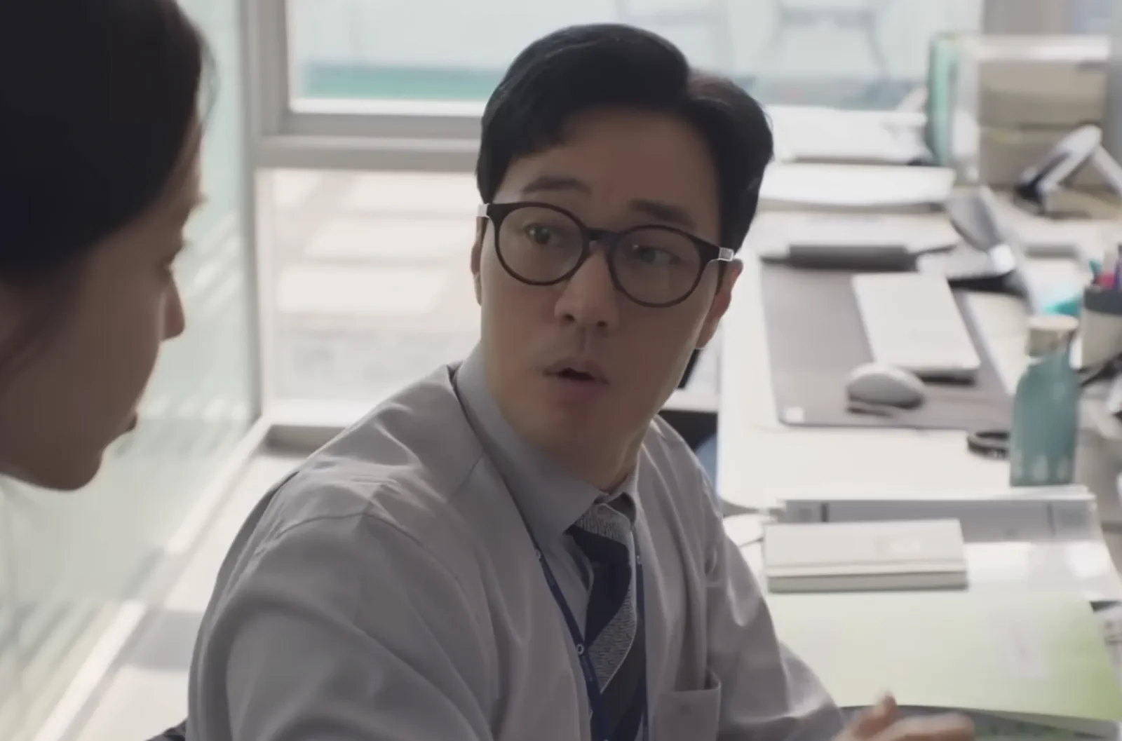 사무실 자리에서 동료와 이야기하는 김부장