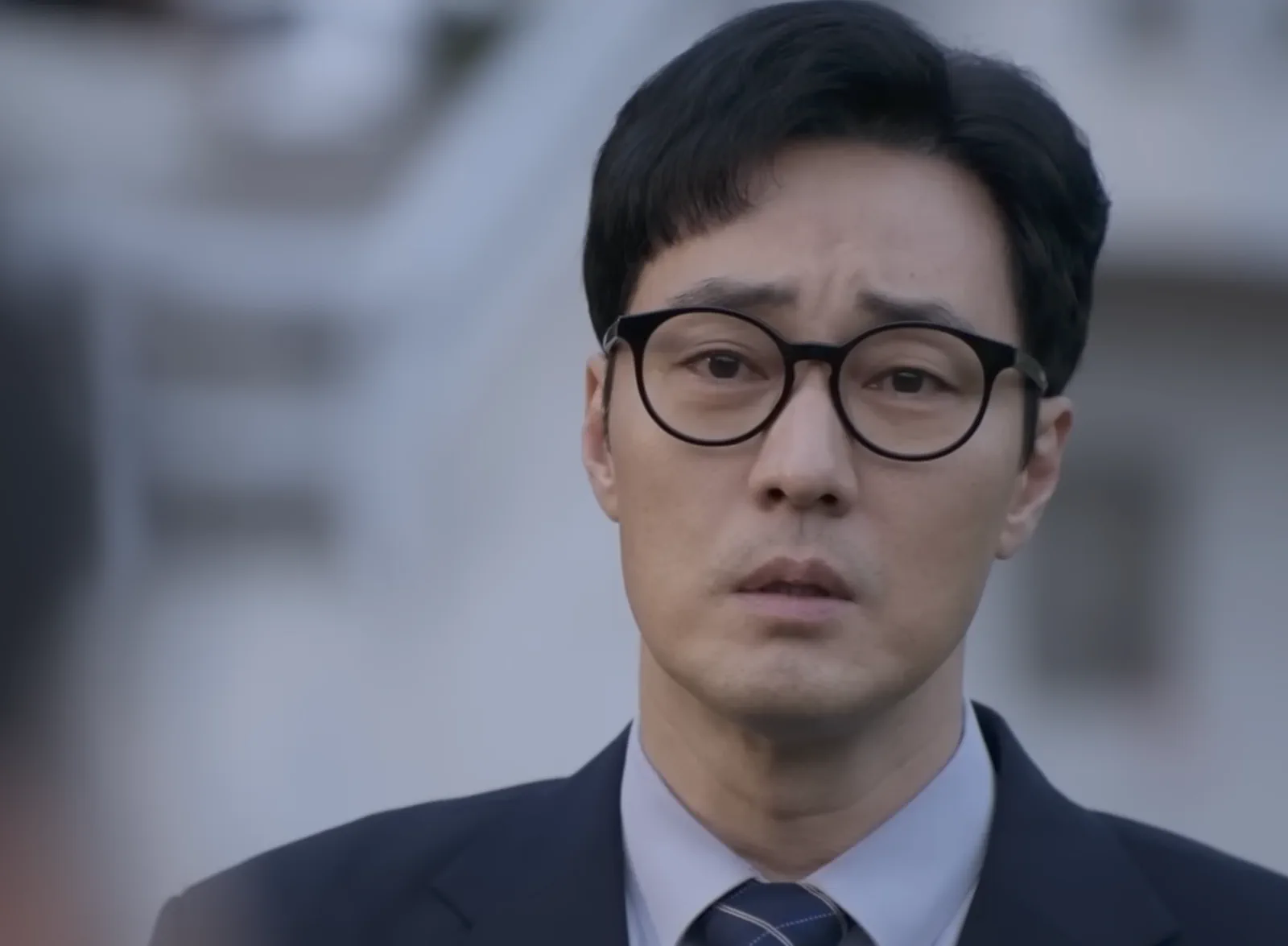 회사 밖에 서서 굳은 표정을 짓고 있는 김부장